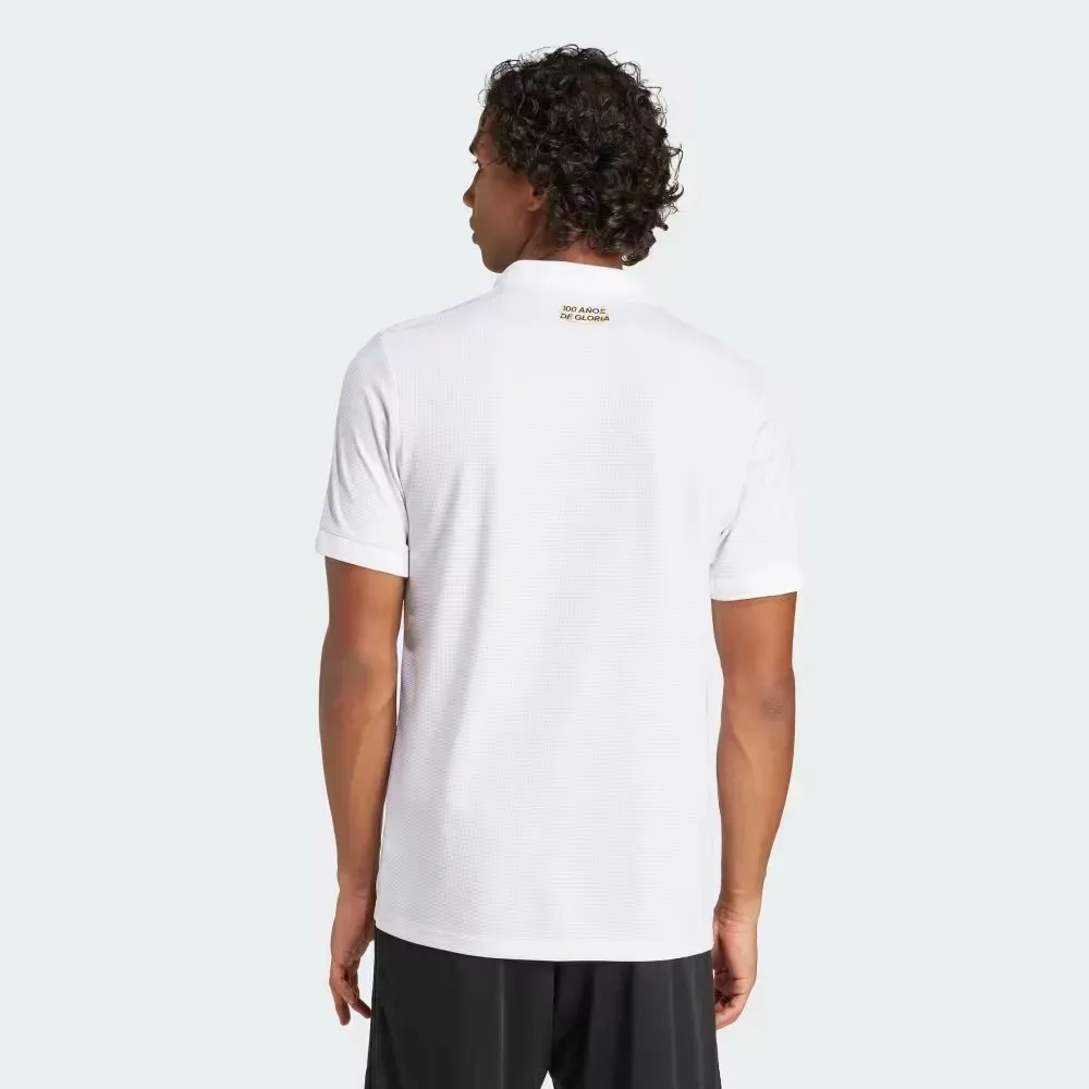En la parte de atrás de la camiseta, está la frase: “100 años de gloria”.