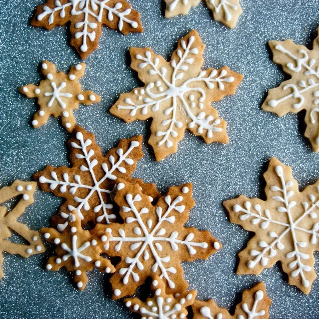 Galleta de copos de Navidad decorado con un glaseado blanco.