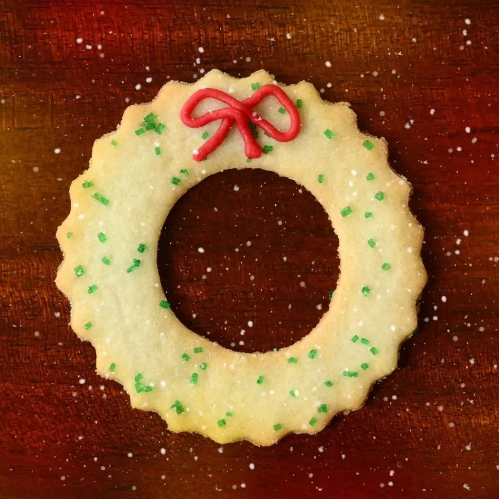 Galleta de guirnalda de Navidad decorada con un glaseado rojo.