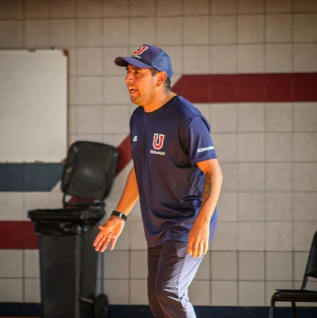 El entrenador comúnmente utiliza la indumentaria de la Universidad de Chile.