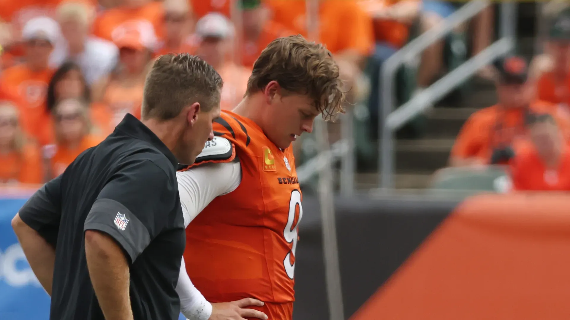 Joe Burrow #9 of the Cincinnati Bengals is helped off the field following an injury.