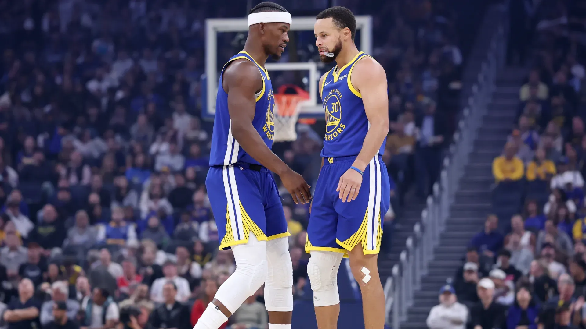 Jimmy Butler talks to Stephen Curry during Warriors’ game against Suns. (Getty Images)
