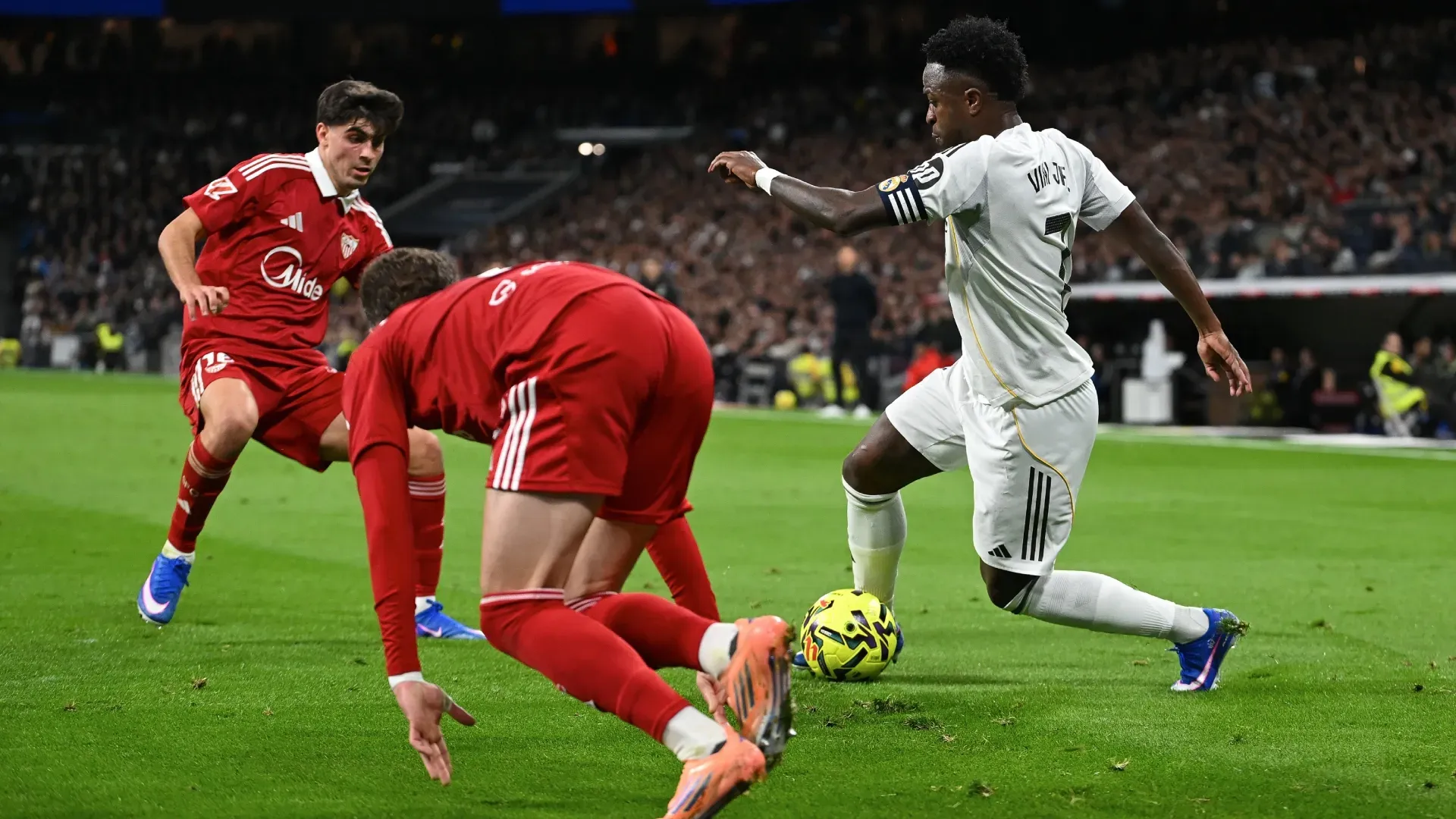 Juan Lu and Jose Angel Carmona of Sevilla challenging Vinicius Junior of Real Madrid