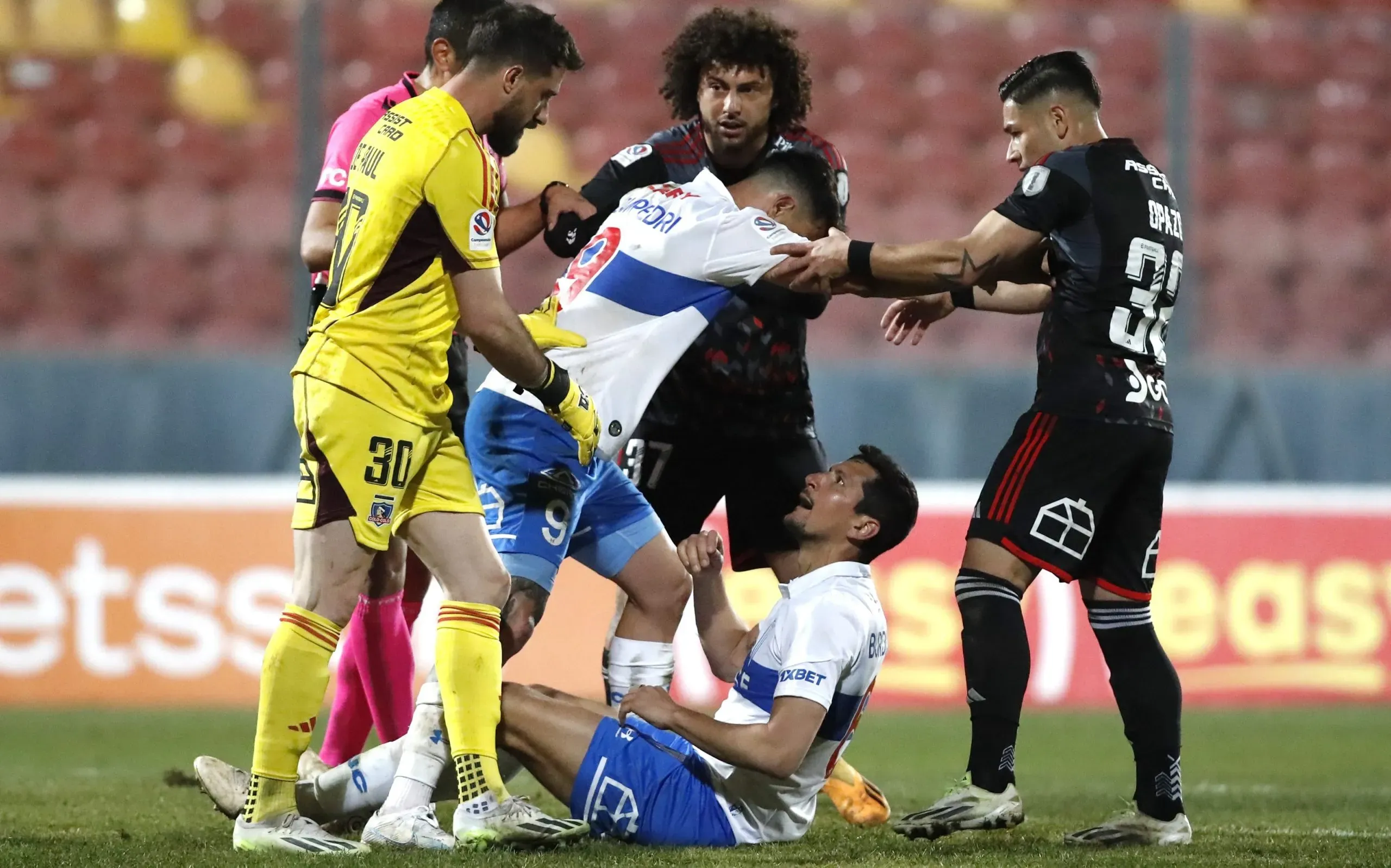 Guillermo Burdisso cae al piso tras supuesto codazo de Darío Lezcano en el partido de Colo Colo vs Universidad Católica (Jonnathan Oyarzun/Photosport).