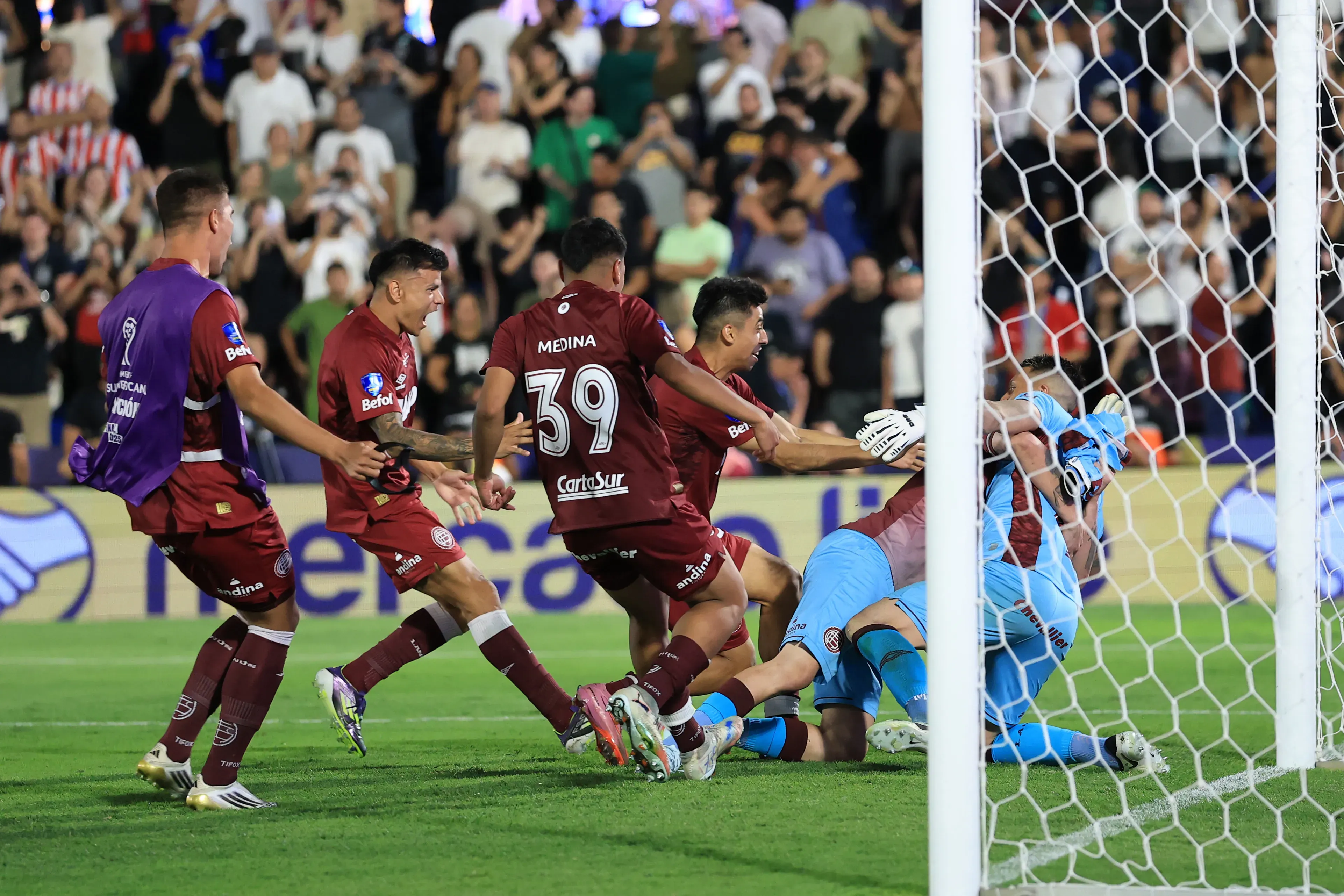 Jogadores do Lanús abraçando Losada após sua defesa decisiva nos pênaltis.  (Foto: Buda Mendes/Getty Images)