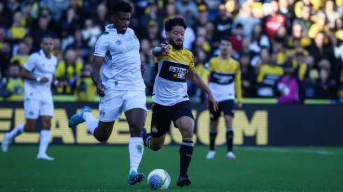  Arthur Caíke jogador do Criciúma disputa lance com Jemerson jogador do Grêmio durante partida no estádio Heriberto Hulse pelo campeonato Brasileiro A 2024. Foto: Leonardo Hübbe/AGIF
