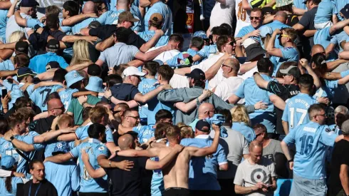 Los hinchas de Manchester City festejan de espaldas.
