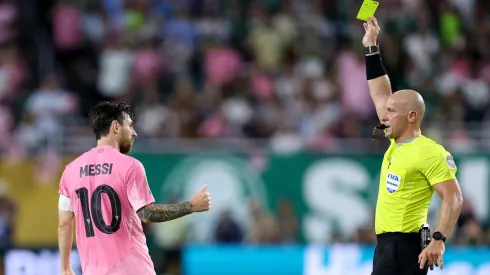 Lionel Messi recibiendo una tarjeta amarilla.