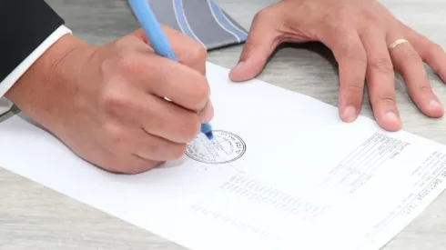 Foto: Pixabay - Uma pessoa assinando um documento.