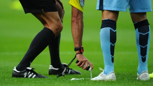 NEWCASTLE UPON TYNE, ENGLAND – AUGUST 17:  Referee Martin Atkinson sprays his magic free kick line spray during the Barclays Premier League match between Newcastle United and Manchester City at St James' Park on August 17, 2014 in Newcastle upon Tyne, England.  (Photo by Stu Forster/Getty Images)
