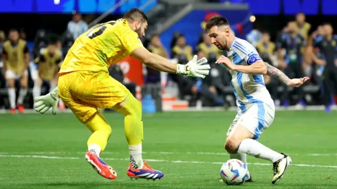 Lionel Messi intenta quitarse de encima al portero de Canadá, Maxime Crépeau.
