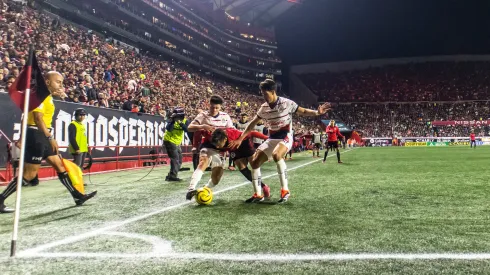 Domingo Blanco de Tijuana pelea el balón con los jugadores de Chivas, José Castillo y Pavel Pérez.
