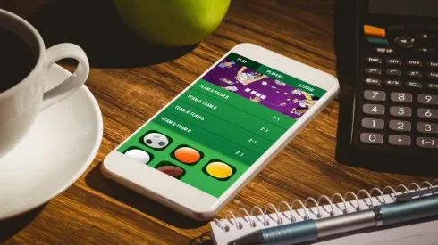 Gambling app screen against smartphone on table

