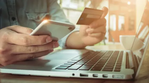 Online payment,Man's hands holding smartphone  and using credit card for online shopping.
