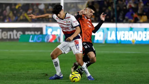 Érick Gutiérrez pelea el balón con Juan Brunetta, en el último enfrentamiento de Chivas con Tigres UANL.
