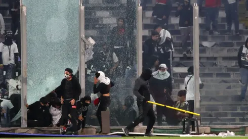 Un grupo de hinchas rompió un vidrio e invadió el campo de juego (Photosport).