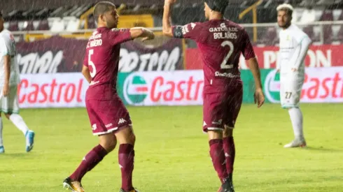 Saprissa's players celebrate a goal by touching elbows
