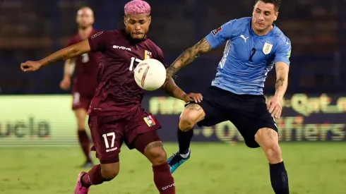 Josef Martínez of Venezuela fights for the ball with José Giménez of Uruguay
