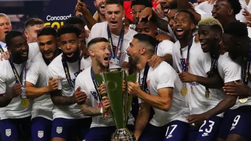 Paul Arriola #7 of United States and Sebastian Lletget #17 lifts the trophy to celebrate with his teammates after winning the CONCACAF Gold Cup 2021
