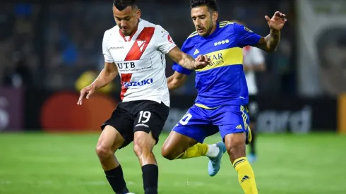 Jorge Flores of Always Ready fights for the ball with Eduardo Salvio of Boca Juniors
