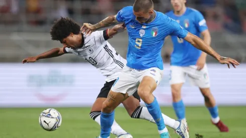 Serge Gnabry of Germany is challenged by Gianluca Scamacca of Italy
