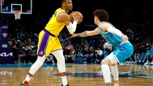 Russell Westbrook of the Los Angeles Lakers looks over the court as he is guarded by LaMelo Ball of the Charlotte Hornets