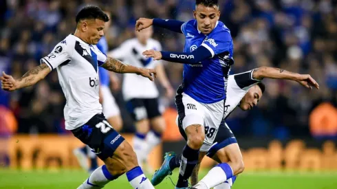 Matias Godoy of Talleres fights for the ball with Walter Bou (L) and Francisco Ortega (R) of Velez
