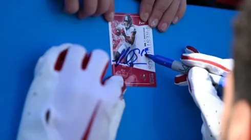 Mike Evans #13 of the Tampa Bay Buccaneers signs a card for a fan during pregame against the Carolina Panthers at Bank of America Stadium on October 23, 2022 in Charlotte, North Carolina.
