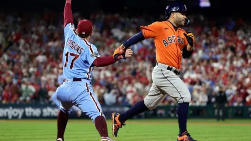 Jose Altuve of the Houston Astros is forced out at first base by Rhys Hoskins of the Philadelphia Phillies
