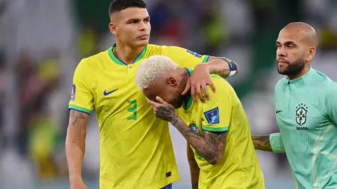 Neymar of Brazil reacts with Thiago Silva (L) and Dani Alves after the loss via a penalty shootout
