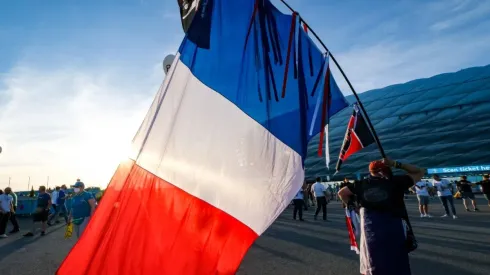 A man carrying a huge French flag
