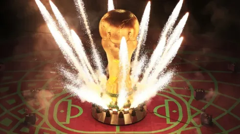 Pyrotechnics explode around a giant World Cup trophy
