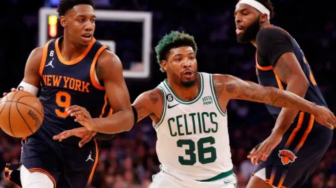 RJ Barrett #9 of the New York Knicks dribbles as Marcus Smart #36 of the Boston Celtics
