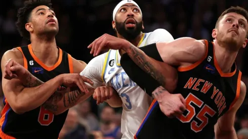 Quentin Grimes #6 and Isaiah Hartenstein #55 of the New York Knicks surround Anthony Davis #3 of the Los Angeles Lakers
