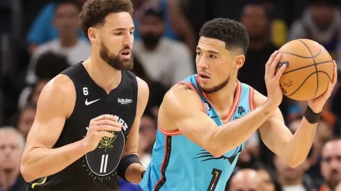 Devin Booker #1 of the Phoenix Suns handles the ball against Klay Thompson #11 of the Golden State Warriors
