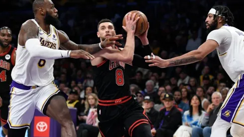 Zach LaVine #8 of the Chicago Bulls drives to the basket in between LeBron James #6 and Anthony Davis #3 of the Los Angeles Lakers
