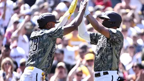 Xander Bogaerts #2 of the San Diego Padres (R) is congratulated by teammate Jose Azocar #28
