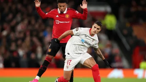 Erik Lamela of Sevilla FC is put under pressure by Jadon Sancho of Manchester United
