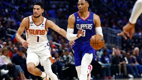 Russell Westbrook #0 of the LA Clippers controls the ball against Devin Booker #1 of the Phoenix Suns

