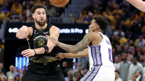 Klay Thompson #11 of the Golden State Warriors passes around Malik Monk #0 of the Sacramento Kings
