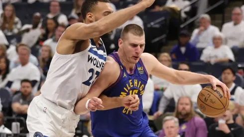 Nikola Jokic #15 of the Denver Nuggets drives around Rudy Gobert #27 of the Minnesota Timberwolves
