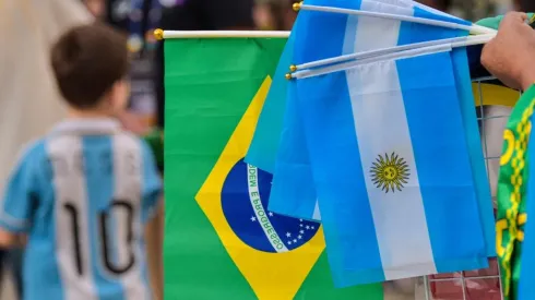 A street vendor holds flags of Argentina and Brazil outside the stadium
