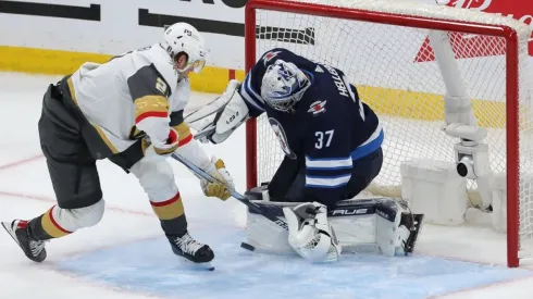 Connor Hellebuyck #37 of the Winnipeg Jets makes a save on Brett Howden #21 of the Vegas Golden Knights