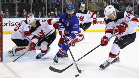 Chris Kreider #20 of the New York Rangers and Nathan Bastian #14 of the New Jersey Devils battle for the puck
