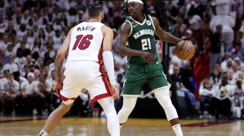 Jrue Holiday #21 of the Milwaukee Bucks controls the ball against Caleb Martin #16 of the Miami Heat
