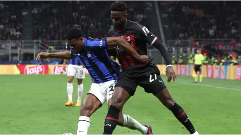 Denzel Dumfries of FC Internazionale is challenged by Divock Origi of AC Milan