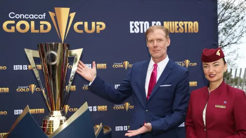 Former U.S. player Alexi Lalas poses with the Gold Cup trophy
