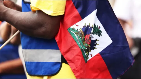 A man holds a Haitian flag
