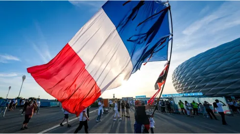 A man carrying a huge French flag
