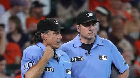 Umpires Phil Cuzzi and Dan Bellino await the review of a play